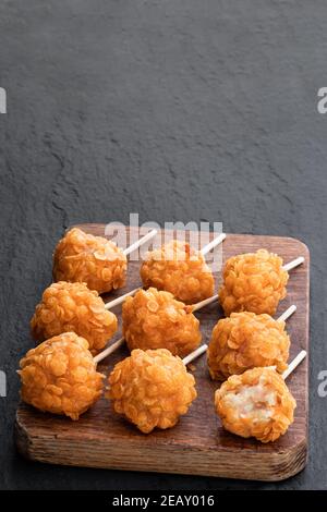 Des sucettes de crevettes royales servies sur une planche de bois sur fond de pierre Banque D'Images