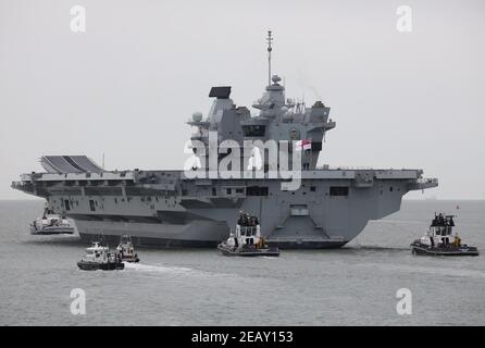 Des remorqueurs et des embarcations de sécurité escortent le porte-avions de la Royal Navy HMS PRINCE DE GALLES dans le Solent Banque D'Images