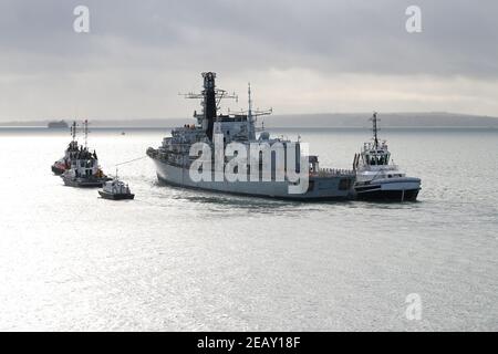 Des remorqueurs remorquent le HMS IRON DUKE DE la frégate de type 23 de la Marine royale dans le Solent. Le navire se dirige vers Plymouth, Royaume-Uni, pour le remontage Banque D'Images