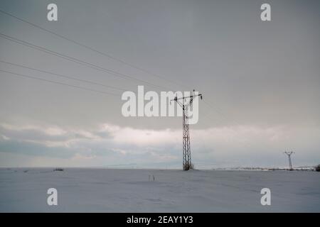 Paysage enneigé d'hiver avec piliers électriques dans le champ Banque D'Images