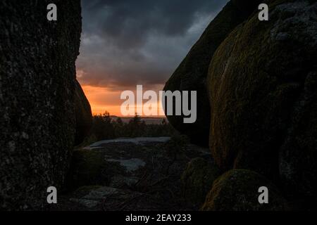 Placer avec beaucoup de grosses pierres couvertes de mousse dans un environnement orageux et jour de gris au coucher du soleil Banque D'Images