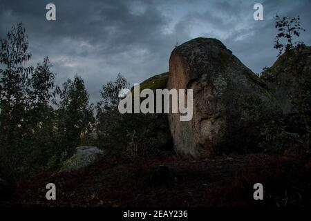 Placer avec beaucoup de grosses pierres couvertes de mousse dans un environnement orageux et jour de gris au coucher du soleil Banque D'Images