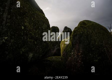 Placer avec beaucoup de grosses pierres couvertes de mousse dans un environnement orageux et un jour gris Banque D'Images