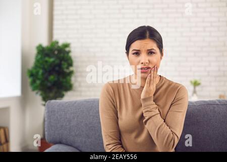 Femme malheureuse souffrant de mal de dents aigu ou de gonflement de la joue après extraction des dents Banque D'Images