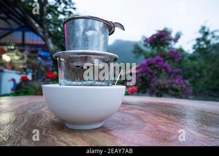 Café expresso dans la marmite de moka ancienne cafetière, le café chaud goutte à goutte dans le style du Vietnam. Petit déjeuner dans la nature sur le fond de la montagne vietnamienne l Banque D'Images