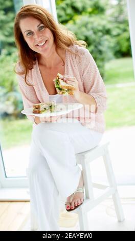 Femme en train de manger un sandwich Banque D'Images