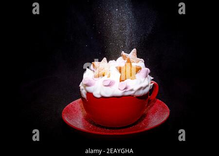 Tasse de café rouge avec café et crème et frais cuits biscuits en forme de chaleur et biscuits étoiles Banque D'Images