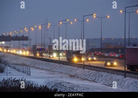 Neige sur l'autoroute en hiver. Circulation difficile pendant une tempête de neige. Transport pendant les heures de pointe. Banque D'Images