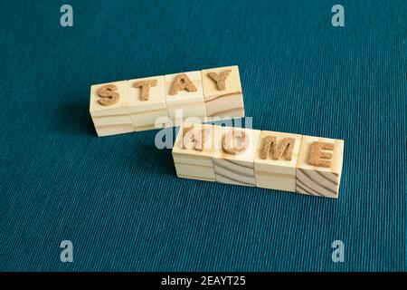 Le mot « Stay Home » est en bois sur fond bleu. REST, Self Quarantine, concept de prévention des virus Banque D'Images