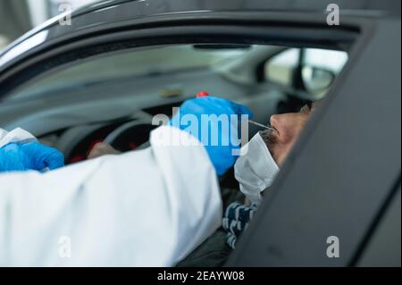 Homme méconnaissable qui fait l'objet d'un test au poste de passage du coronavirus Banque D'Images