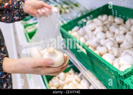 Une femme choisit des champignons dans un supermarché. Mise au point sélective. Nourriture. Banque D'Images
