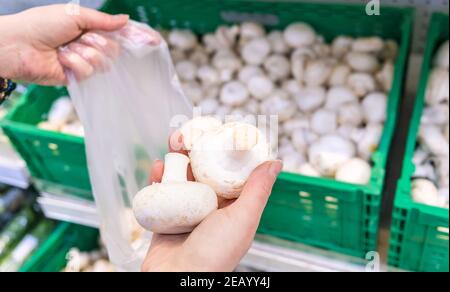 Une femme choisit des champignons dans un supermarché. Mise au point sélective. Nourriture. Banque D'Images