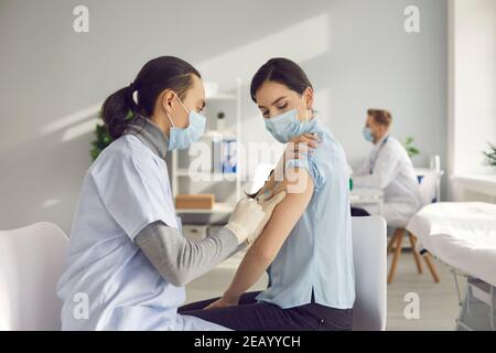 La jeune femme se fait vacciner à la clinique ou au centre de santé pendant Pandémie mondiale de Covid-19 Banque D'Images