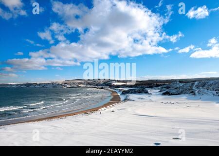 CULLEN BAY MORAY FIRTH SCOTLAND UN CIEL BLEU EN HIVER LA NEIGE COUVRE LES MAISONS DE VILLE DU TERRAIN DE GOLF ET LA PLAGE DE SABLE Banque D'Images