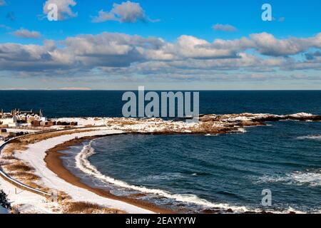 FINDOCHTY MORAY FIRTH SCOTLAND BLEU CIEL UNE VUE D'HIVER LA PLAGE ENNEIGÉE ET LES MAISONS DU VILLAGE Banque D'Images
