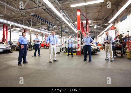 Portrait de six mécaniciens en atelier de réparation automobile vu de ci-dessus Banque D'Images