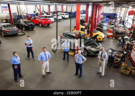 Portrait de six mécaniciens en atelier de réparation automobile vu de ci-dessus Banque D'Images