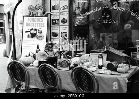 PARIS, FRANCE - 14 FÉVRIER 2019 : fondue et raclette exposées (attirer les clients) dans un restaurant traditionnel typique du quartier Latin. Couple senior Banque D'Images