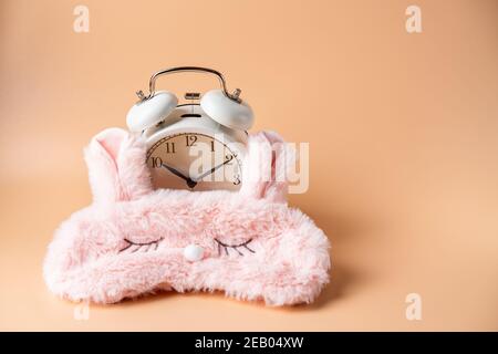 Masque de sommeil, réveil isolé sur fond rose pastel coloré et tendance. Ne me dérange pas, laissez-moi dormir. Banque D'Images