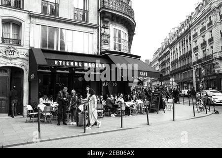 PARIS, FRANCE - 6 AVRIL 2019 : les Parisiens et les touristes s'assoient sur la terrasse du café Etienne Marcel de la rue Montmartre. Photo historique noir blanc Banque D'Images