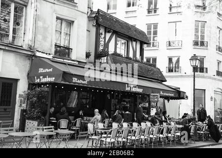 PARIS, FRANCE - 6 AVRIL 2019 : les Parisiens et les touristes s'assoient sur la terrasse du café le Tambur. Photo historique noir blanc Banque D'Images