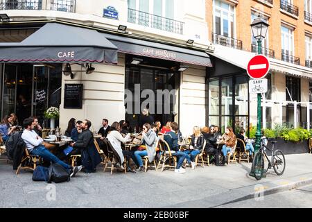 PARIS, FRANCE - 6 AVRIL 2019 : les Parisiens et les touristes s'assoient sur la terrasse d'un café en centre-ville. Les cafés de Paris semblent être un important culturel et soc Banque D'Images