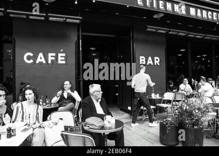 PARIS, FRANCE - 6 AVRIL 2019 : les Parisiens et les touristes s'assoient sur la terrasse du café Etienne Marcel de la rue Montmartre. Photo historique noir blanc Banque D'Images