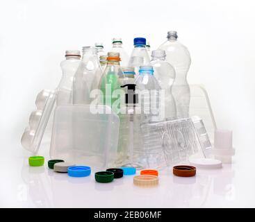 Collection de matériaux à base de plastique domestique, filés sur un fond blanc avec réflexion. Flacons, plateaux alimentaires, conteneur à pompe prêt pour le recyclage. Banque D'Images