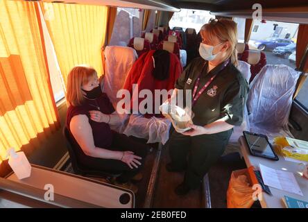 Le paramédic Jill Fletcher s'entretient avec Fiona Newitt après avoir donné un vaccin à l'intérieur d'un autocar de vacances à l'extérieur de Culloden Medical Practice près d'Inverness, en Écosse, qui est utilisé par le Scottish Ambulance Service comme centre mobile de vaccination contre le coronavirus. Date de la photo : jeudi 11 février 2021. Banque D'Images