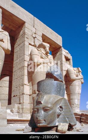 Temple mortuaire de Ramsès II (le Ramesseum) dans la nécropole thébaine près de Louxor, Haut Nil, Égypte. Piliers et colonnes Osiride avec une tête en granit de Young Memnon. Numérisation d'archivage à partir d'une lame. Février 1987. Banque D'Images