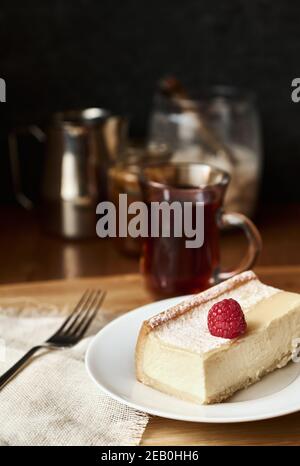 Tranche de cheesecake savoureux sur une assiette blanche, gâteau au fromage classique de style New York, gros plan Banque D'Images