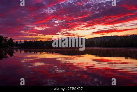 Lac Wilson dans l'ouest du Québec, Canada lever du soleil tôt le matin reflet coloré sur un lac calme. Banque D'Images
