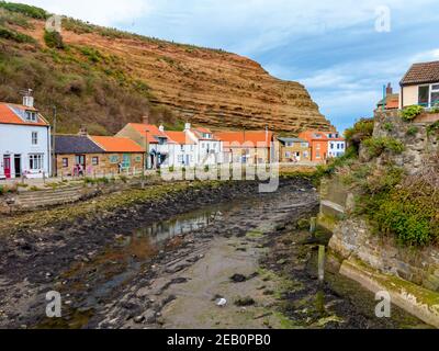 Vue sur la rivière et les maisons traditionnelles avec toits de tuiles rouges Dans Staithes un village de bord de mer dans le Yorkshire du Nord sur côte nord-est de l'Angleterre Royaume-Uni Banque D'Images