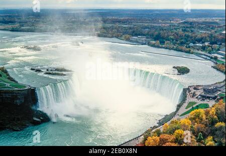 1995 Canada Niagara Falls est une ville de l'Ontario, au Canada. Elle se trouve sur la rive ouest de la rivière Niagara, dans la région du Golden Horseshoe, dans le sud de l'Ontario, et la rivière Niagara traverse les chutes Niagara à cet endroit. Les chutes canadiennes, également connues sous le nom de chutes canadiennes, sont à cheval sur la frontière internationale du Canada et des États-Unis. Vue aérienne des chutes du Niagara ou de la chute en fer à cheval depuis la tour Skylon, une tour d'observation qui surplombe les chutes en fer à cheval et une plate-forme d'observation touristique Niagara Falls, Ontario, Canada Banque D'Images