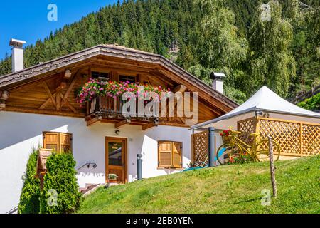 Maison alpine traditionnelle dans le village de Trentin-Haut-Adige avec montagnes des Alpes en arrière-plan. Vallée de la Cembra, province de Trento - nord de l'Italie Banque D'Images