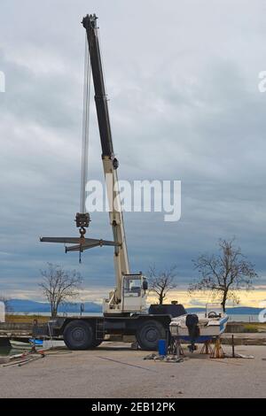 Un pont élévateur ou un palan mobile hydraulique suspendu à l'aide d'une élingue. Situé dans une marina hors saison dans le nord de l'Italie Banque D'Images