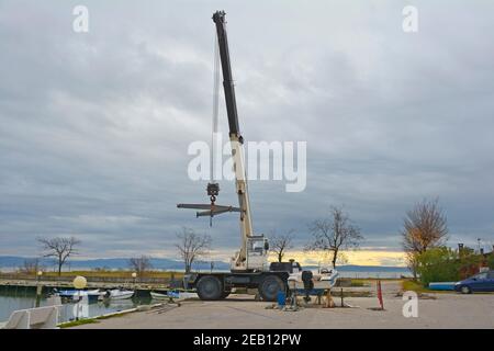 Un pont élévateur ou un palan mobile hydraulique suspendu à l'aide d'une élingue. Situé dans une marina hors saison dans le nord de l'Italie Banque D'Images