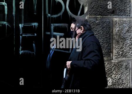 Un homme passe devant un arrêt de bus à graffitité, Barcelone, Espagne. Banque D'Images