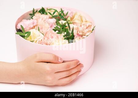 Femme tenant une boîte cadeau avec des fleurs pour le 8 mars, journée internationale des femmes, jour de la Saint Valentin, jour des mères heureux Banque D'Images