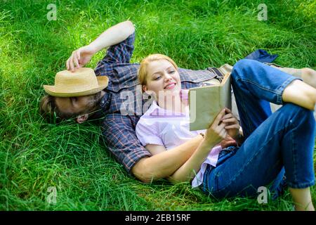 Couple romantique famille Profitez de loisirs avec la poésie ou la littérature herbe fond. Couple de soulmates à une date romantique. Couple amoureux passer livre de lecture de loisirs. L'homme et la fille se détendent sur l'herbe en se relaxant. Banque D'Images