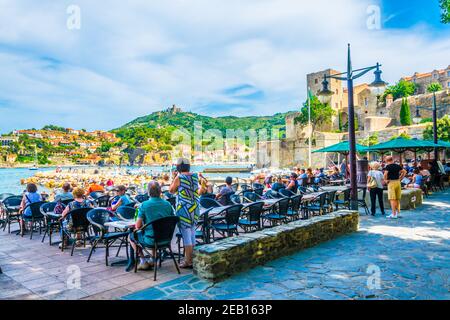 COLLIOURE, FRANCE, 26 JUIN 2017 : les gens sont assis dans un restaurant en face du château royal de Collioure, France Banque D'Images