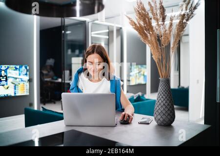 Gamer féminin jouant à des jeux vidéo à la maison à l'aide d'un ordinateur portable. Joueur professionnel testant des jeux vidéo en ligne sur son ordinateur personnel avec la technologie moderne Banque D'Images