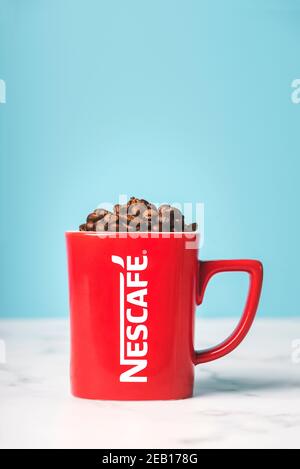 Tasse de Nescafé rouge avec grains de café sur un marbre tableau Banque D'Images