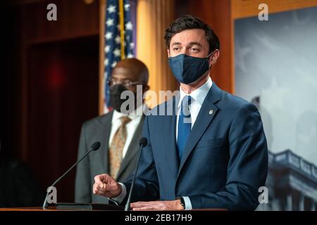 Washington, États-Unis. 11 février 2021. Le sénateur Raphael Warnock (D-GA), au centre, et le chef de la majorité au Sénat Charles Schumer, D-NY, écoutent à droite comme le sénateur Jon Ossoff (D-GA), parle au Capitole des États-Unis le 11 février 2021 à Washington, DC. Schumer a parlé de la nécessité d'adopter le plan de secours de la COVID-19 dans le cadre de la résolution budgétaire. Photo de Ken Cedeno/Sipa U. sa crédit: SIPA USA/Alay Live News Banque D'Images