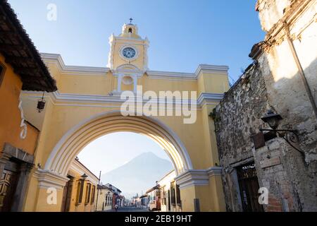 Arche de Santa Catalina et maisons coloniales dans l'avenue principale D'Antigua Guatemala avec volcan d'eau en arrière-plan - arc jaune de la ville coloniale dans Banque D'Images