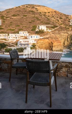 Table et chaise donnant sur la plage d'Agali sur l'île de Folegandros. Cyclades, Grèce Banque D'Images