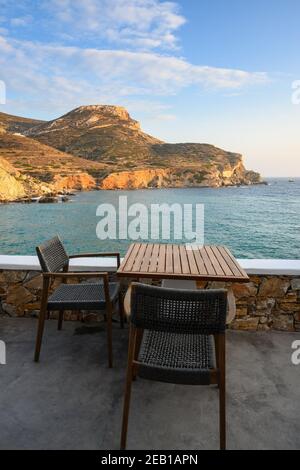 Table et chaise donnant sur la plage d'Agali sur l'île de Folegandros. Cyclades, Grèce Banque D'Images