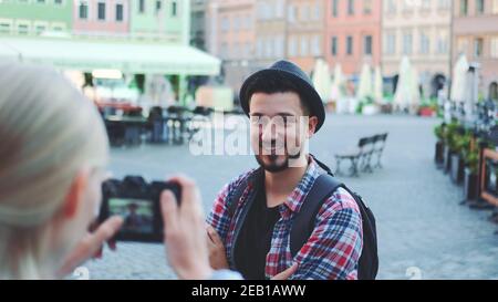 Gros plan moyen de quelques touristes faisant des photos avec photo appareil photo sur la place du marché historique. Homme posant et femme prenant des photos. Banque D'Images