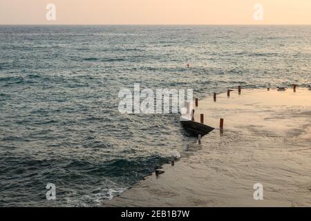 Quai sur la plage d'Agali sur l'île de Folegandros au coucher du soleil. Cyclades, Grèce Banque D'Images