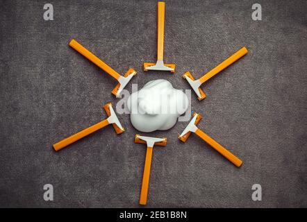 Rasoirs jetables orange comme le soleil et la crème de rasage gris Banque D'Images